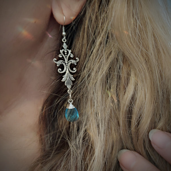 Created in our studio, these unique earrings are lightweight and so beautiful to wear! The stunning Blue Topaz dangles from an Art Nouveau Style Filigree base. Really lovely on!
 
Comes in a Black Velvet drawstring bag for safe keeping, or gifting.

 2.5" length with hooks

Genuine Labradorite and Amazonite, Brass