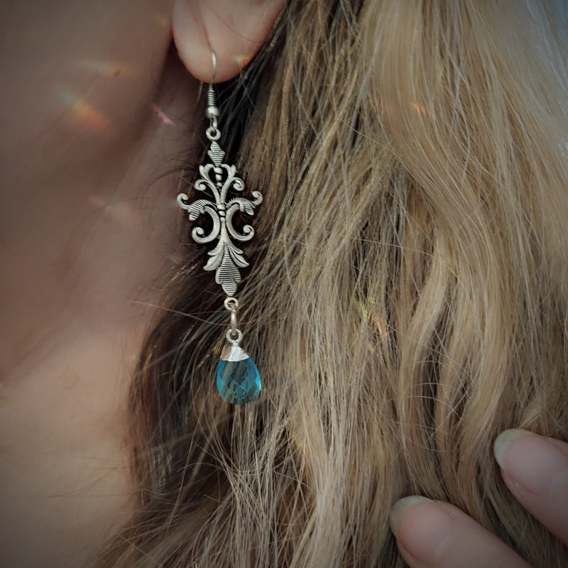 Created in our studio, these unique earrings are lightweight and so beautiful to wear! The stunning Blue Topaz dangles from an Art Nouveau Style Filigree base. Really lovely on!
 
Comes in a Black Velvet drawstring bag for safe keeping, or gifting.

 2.5" length with hooks

Genuine Labradorite and Amazonite, Brass